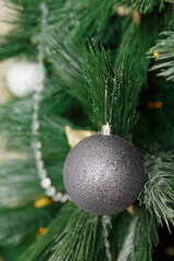 Christmas toy ball hanging on a branch of spruce. New year tree decorated with a garland