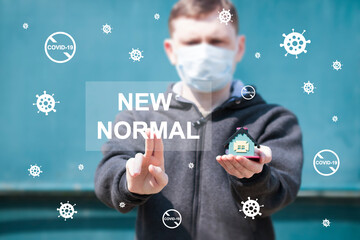 Man hand presses button with word NEW NORMAL. Adapting to new life or business post-lockdown after...