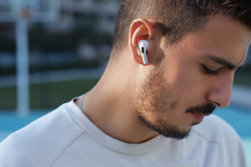 Bluetooth headphones on the ear of a young male person. 