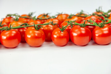 Tomato cherry on branch isolated on white background.
