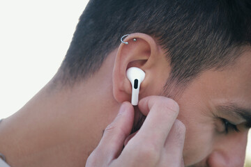 Bluetooth headphones on the ear of a young male person. 