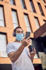 Masked man  listening to music with headphones