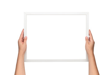 White frame. Woman hanging a frame.