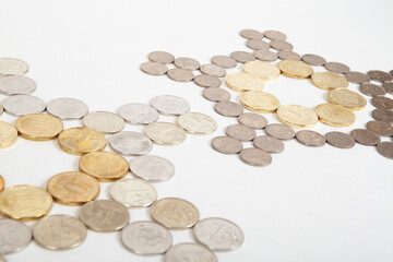 Coins laid out in the shape of a clock on a white background