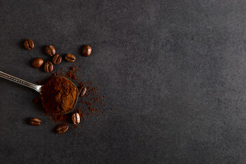 Spoon and scattered grains coffee on a stone table. Authentic drink, copy space.