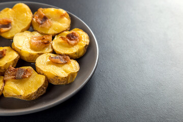 Baked potatoes with lard, a strata-fast delicious lunch, in a plate on a stone table. Copy space.