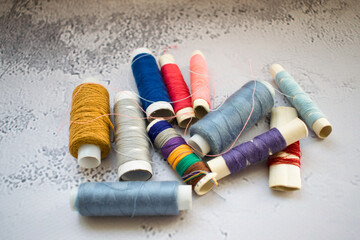 Fototapeta na wymiar Multicolored spools of thread on light background. Threads close up