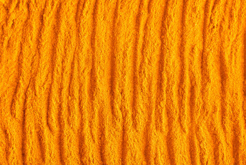 Orange turmeric powder (pumpkin facial mask, body scrub) texture close up. Abstract background with brush strokes.