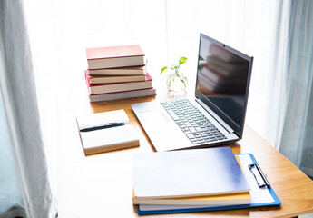 Laptop and book study materials on the desk