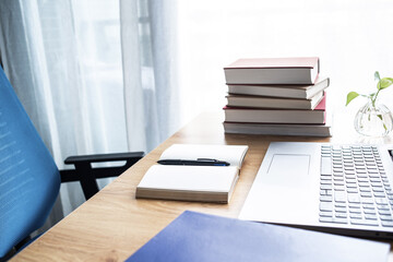 Laptop and book study materials on the desk
