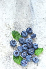 Fresh blueberries in on light gray concrete background with copy space close up. Concept for healthy eating and nutrition.