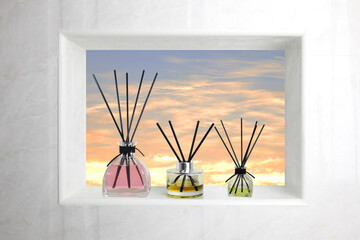 The luxury aroma reed diffuser glass bottle is displayed on the  toilet bathroom's window with the view of sun set cloud and twilight sky