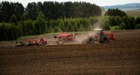 large tractor with plow plows  field before spring sowing of crops. tractor with  harrow drives...