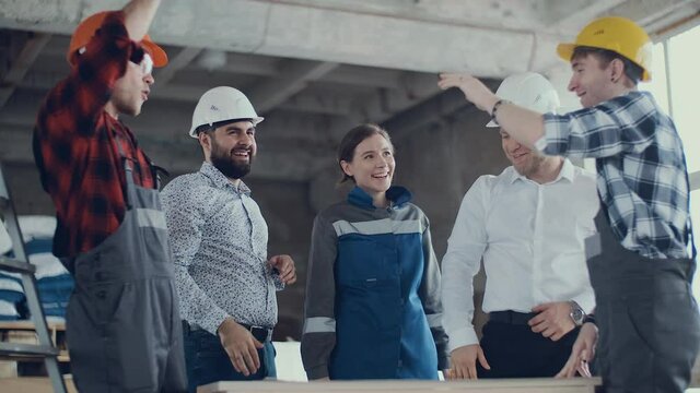 Happy team of civil engineers give high five together, celebrate success, good results, reward in teamwork concept.