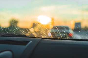 Obraz premium Defocused bokeh light. Sunset city blurred behind a dirty car window.