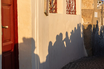 shadows of sunset watchers in oia greece