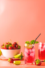Two glasses with water drops of Strawberry mojito cocktail on soft pink color background. Copy space, summer vacation and party concept