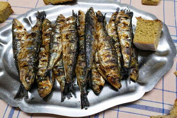 Grilled sardines with bread served on a tray