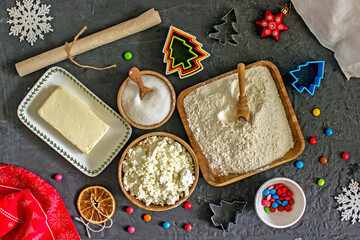 Ingredients for making Christmas cookies. Cottage cheese, flour, sugar, eggs, butter on a blue...