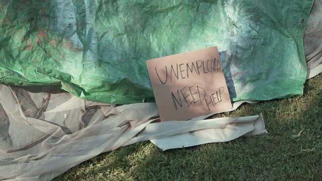 unemployed sign by homeless tent