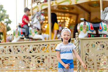 Obraz na płótnie Canvas a cheerful child a boy of 5-6 years old walks in an amusement Park. Children lifestyle