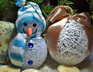 New Year and Christmas decorations with lighting Snowman, New Year tree, candles and white handmade ball. Greeting card. 