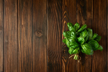 Fresh green basil on brown rustic wooden background. Top view. Flat lay