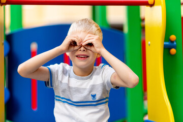 Obraz premium happy baby boy 5-6 years old playing on the Playground in the yard in the summer. Children's lifestyle