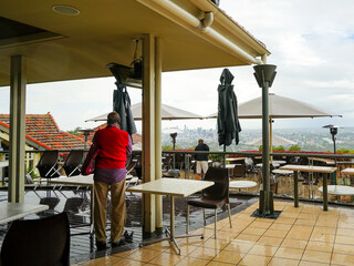 Fototapeta premium Empty outdoor cafe on a rainy day, with a view of the city skyline in the distance.