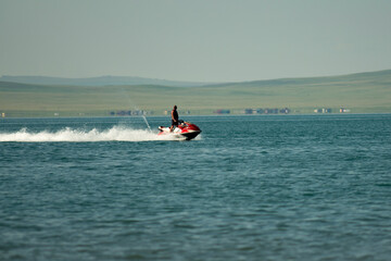Fototapeta premium A man on a jet ski in the middle of the lake. Speedy rest on the water.