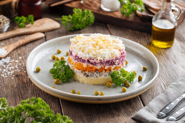 Layer russian salad herring under coat