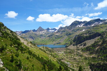 Respumoso dam (Embalse de Respumoso) among barren rocky mountains with snow and blue sky in a sunny...