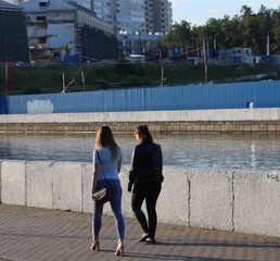 young girls walking near city quayside in europe