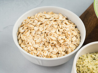 Oat flakes in bowl on gray background