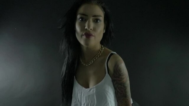 Sexy Girl in a white top and black shorts dancing in the studio. Tattoos