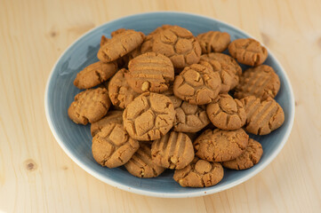 Very tasty peanut butter biscuits on bamboo light brown wooden board, golden baked healthy