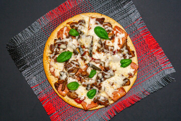 pizza with mushrooms, Basil and cheese on a dark background. copy space. The view from the top. flat lay