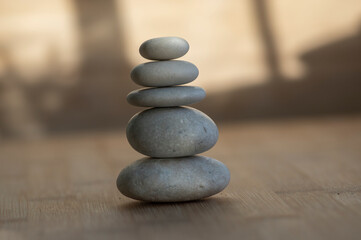Stone cairn on striped grey white background, five stones tower, simple poise stones, simplicity harmony and balance,