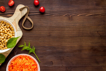 Vegetarian bowl with chickpeas and vegetables - wooden table top view copy space