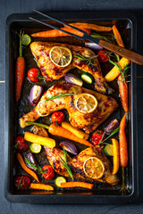 Grilled chicken legs with various vegetables and herbs.