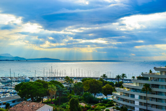 Beautiful sunbeams at sunset on the background of the cloudy sky.  Villeneuve-Loubet. France.