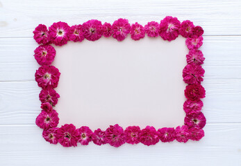 Floral frame of red roses on white wooden background. Copy space,mockup