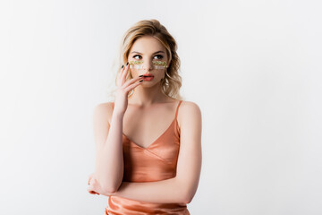 Fototapeta premium beautiful blonde woman in silk dress with wildflowers under eyes isolated on white