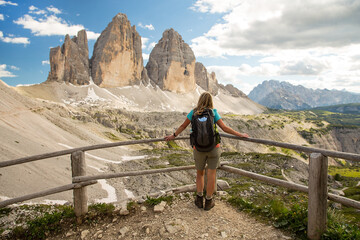 Adult hiker poses on bridge in front of Tre cime di Lavaredo - Dolomiti Alps