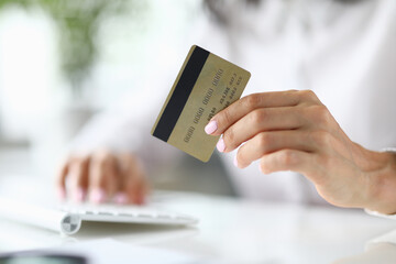 Female hand holds bank plastic card. Safe online payments via internet concept