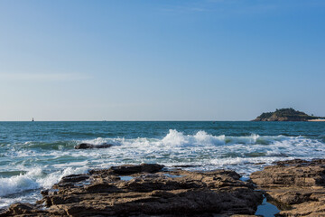 Aerial top view of sea waves hitting rocks on the beach