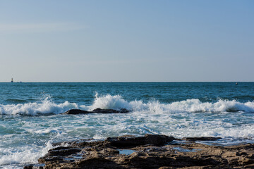 Aerial top view of sea waves hitting rocks on the beach