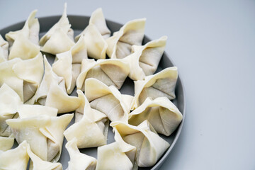 Traditional Chinese food wonton is placed on gray plate.