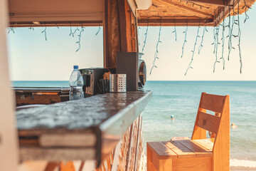 Sunny. An empty bar counter and an empty chair against the background of the beach and the sea....