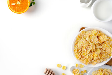 Corn flakes bowl sweeties with milk and orange on white background, close up, fresh and healthy breakfast design concept.